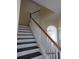 Elegant staircase with dark wood steps and white railings at 7423 Pulteney Dr, Zephyrhills, FL 33545