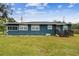 Blue house with a spacious yard and wooden steps at 7513 E 23Rd Ave, Tampa, FL 33619