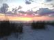 Sunset over the ocean viewed from a sandy beach with seagrass at 11300 7Th E St, Treasure Island, FL 33706