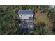 Aerial view of a home with solar panels, screened pool, and spacious backyard surrounded by trees at 1406 Butch Cassidy Trl, Wimauma, FL 33598