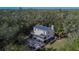 Aerial view of house with solar panels, pool, and lush landscaping at 1406 Butch Cassidy Trl, Wimauma, FL 33598