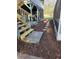 Landscaped backyard with wooden steps, mulch, and paver walkway, providing backyard access at 1406 Butch Cassidy Trl, Wimauma, FL 33598