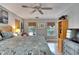 Main bedroom with a king-size bed, ceiling fan, and access to a private balcony at 1406 Butch Cassidy Trl, Wimauma, FL 33598