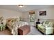 Spacious bedroom with a leafy patterned bedspread and sitting area at 1406 Butch Cassidy Trl, Wimauma, FL 33598