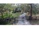 Long driveway leading to a house with a unique gate at 1406 Butch Cassidy Trl, Wimauma, FL 33598