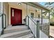 Red front door entrance with a covered porch and white railing at 1406 Butch Cassidy Trl, Wimauma, FL 33598