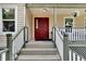Red front door entrance with a covered porch and white railing at 1406 Butch Cassidy Trl, Wimauma, FL 33598