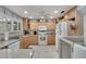 Galley style kitchen with light wood cabinets, granite countertops and appliances at 1406 Butch Cassidy Trl, Wimauma, FL 33598