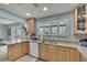 Bright kitchen features light wood cabinets, granite countertops, and stainless steel appliances at 1406 Butch Cassidy Trl, Wimauma, FL 33598