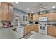 Bright kitchen features light wood cabinets, granite countertops, and stainless steel appliances at 1406 Butch Cassidy Trl, Wimauma, FL 33598