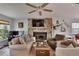 Spacious living room with stone fireplace, large windows and hardwood floors at 1406 Butch Cassidy Trl, Wimauma, FL 33598