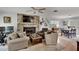 Cozy living room featuring a stone fireplace, comfy seating, and hardwood floors at 1406 Butch Cassidy Trl, Wimauma, FL 33598