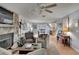 Bright living room with hardwood floors, stone fireplace and open concept to kitchen at 1406 Butch Cassidy Trl, Wimauma, FL 33598