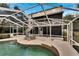 Relaxing screened-in pool with two lounge chairs at 1406 Butch Cassidy Trl, Wimauma, FL 33598