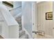 Gray carpeted staircase with white railings and access to a half bathroom at 1406 Butch Cassidy Trl, Wimauma, FL 33598
