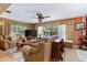 Living room with leather furniture, view of the pool through sliding glass doors, and unique decor at 1625 Leisure Dr, Clearwater, FL 33756