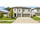 Two-story house with gray siding, two-car garage, and a well-manicured lawn at 16615 Parker River St, Wimauma, FL 33598