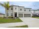 Two-story house with gray siding, two-car garage, and landscaping at 16615 Parker River St, Wimauma, FL 33598