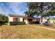 Single-story home with a welcoming walkway, red shutters, and lush landscaping at 2008 Culberson Ave, Dunedin, FL 34698