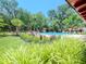 Community pool featuring chairs, tables, and luscious landscaping at 2612 Pearce Dr # 304, Clearwater, FL 33764