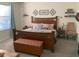 Bedroom with a large wooden bed, leather storage chest, decorative wall art, and neutral-toned carpet at 3509 Maple Grove Way, Plant City, FL 33565