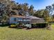 Screened-in pool surrounded by grass and shrubs at 3741 New River Rd, Wesley Chapel, FL 33543