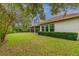 Backyard with green lawn, mature trees, and a privacy hedge at 5212 Candler View Dr, Lithia, FL 33547