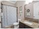 This bathroom features a granite countertop vanity, a toilet, and a shower with a blue-patterned curtain at 5212 Candler View Dr, Lithia, FL 33547