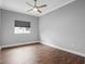 Neutral bedroom featuring wood floors, ceiling fan, and natural light from the window at 5212 Candler View Dr, Lithia, FL 33547
