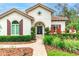Charming home featuring a tile roof, arched entryway, and professionally landscaped front yard with mature trees at 5212 Candler View Dr, Lithia, FL 33547