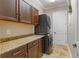 This laundry room features a stacked washer and dryer, a door to the side yard, and overhead cabinets at 5212 Candler View Dr, Lithia, FL 33547