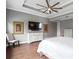 This main bedroom includes a ceiling fan, a flatscreen television, two framed prints, a dresser, and a chair at 5212 Candler View Dr, Lithia, FL 33547