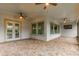 Covered patio featuring paver flooring, multiple ceiling fans, and sliding glass doors at 5212 Candler View Dr, Lithia, FL 33547