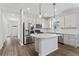 Kitchen featuring an island, stainless steel appliances, white cabinets, and wood-look flooring at 6421 Mooring Line Cir, Apollo Beach, FL 33572