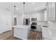 Bright kitchen with white cabinets, an island with white countertop, stainless steel appliances, and wood-look flooring at 6421 Mooring Line Cir, Apollo Beach, FL 33572
