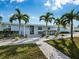 Light blue house with palm trees, walkway, and landscaping at 744 Jungle Queen Way, Longboat Key, FL 34228