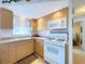 Bright kitchen featuring light wood cabinets and white appliances at 7725 38Th N Pl, St Petersburg, FL 33709