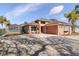 Tan one-story house with red door, two-car garage, and a long driveway at 8049 Hutchinson Dr, New Port Richey, FL 34653