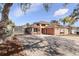 Tan one-story house with red door, two-car garage, and a long driveway at 8049 Hutchinson Dr, New Port Richey, FL 34653