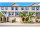 Three story tan townhouses with purple shutters and palm trees at 805 Callista Cay Loop, Tarpon Springs, FL 34689