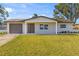 Renovated home with a covered entryway, fresh landscaping, and an attached garage at 9890 54Th N St, Pinellas Park, FL 33782