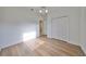 Empty bedroom with wood-look floors, white walls, closet and view of hallway at 1141 Emerald Dunes Dr, Sun City Center, FL 33573