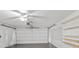 Spacious garage interior with white walls, gray flooring, and built-in shelving at 11902 Snapdragon Rd, Tampa, FL 33635