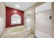 Spacious bathroom featuring a soaking tub, separate shower, and red accent wall at 1304 N Jasmine Ave, Tarpon Springs, FL 34689