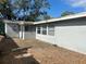 Back exterior view with a concrete patio, windows, and dry grass at 1386 19Th St, Sarasota, FL 34234
