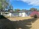 Back exterior of a single-story home with a large backyard and some trees at 1386 19Th St, Sarasota, FL 34234