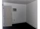 White walled room with dark wood-look laminate floors, door, and window AC unit at 1386 19Th St, Sarasota, FL 34234