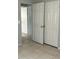 View of a bedroom with gray walls, tile floor, and double doors open to another room at 1386 19Th St, Sarasota, FL 34234
