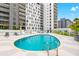 Inviting community pool area with lounge chairs, umbrellas, and city views at 199 Dali Blvd # 302, St Petersburg, FL 33701