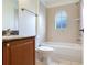 Bathroom with tiled shower and floor, vanity, toilet and arched window at 2606 Espana Ct, Tampa, FL 33609